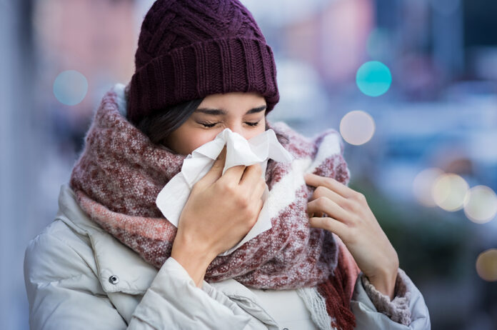 Woman blowing nose outdoor